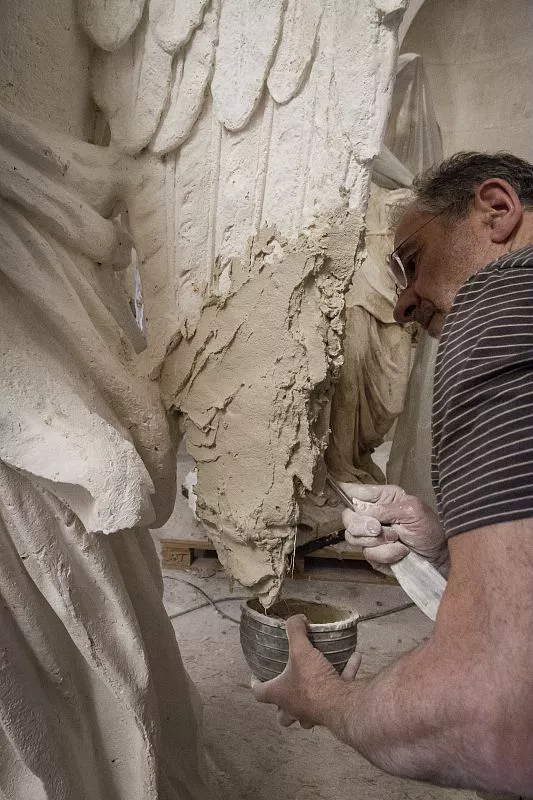 Le sculpteur peut désormais, sur le modèle en plâtre, faire ses propositions de comblement, et de restitution. Ici un morceau d'aile.