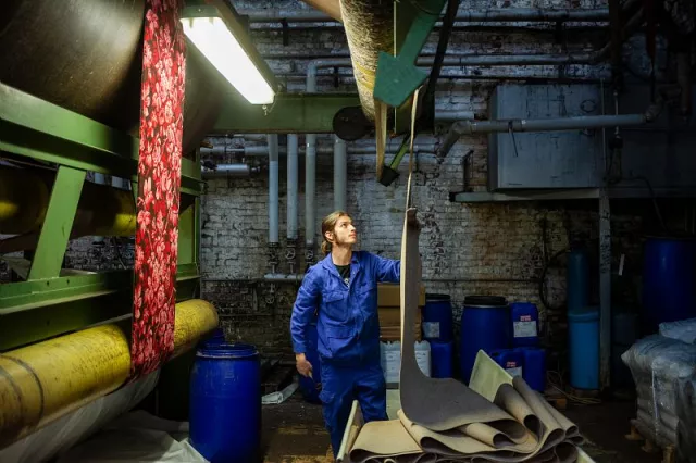 Lors de la même opération, les pièces de moquette sont légèrement enduite de colle au revers afin de rendre le dossier plus résistant et éviter les déformations du tissage. Mises ensuite en balles, elles peuvent être livrées.