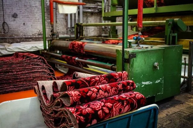 A l'issue du tissage, la moquette est retondue une fois pour assurer une hauteur de poil homogène ; chaque pièce passe sur un cylindre remplie d'eau chaude ;